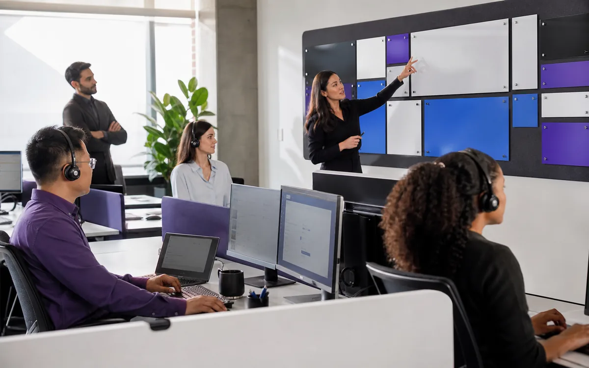 Customer service team coordinating calls and digital conversations in one operations room