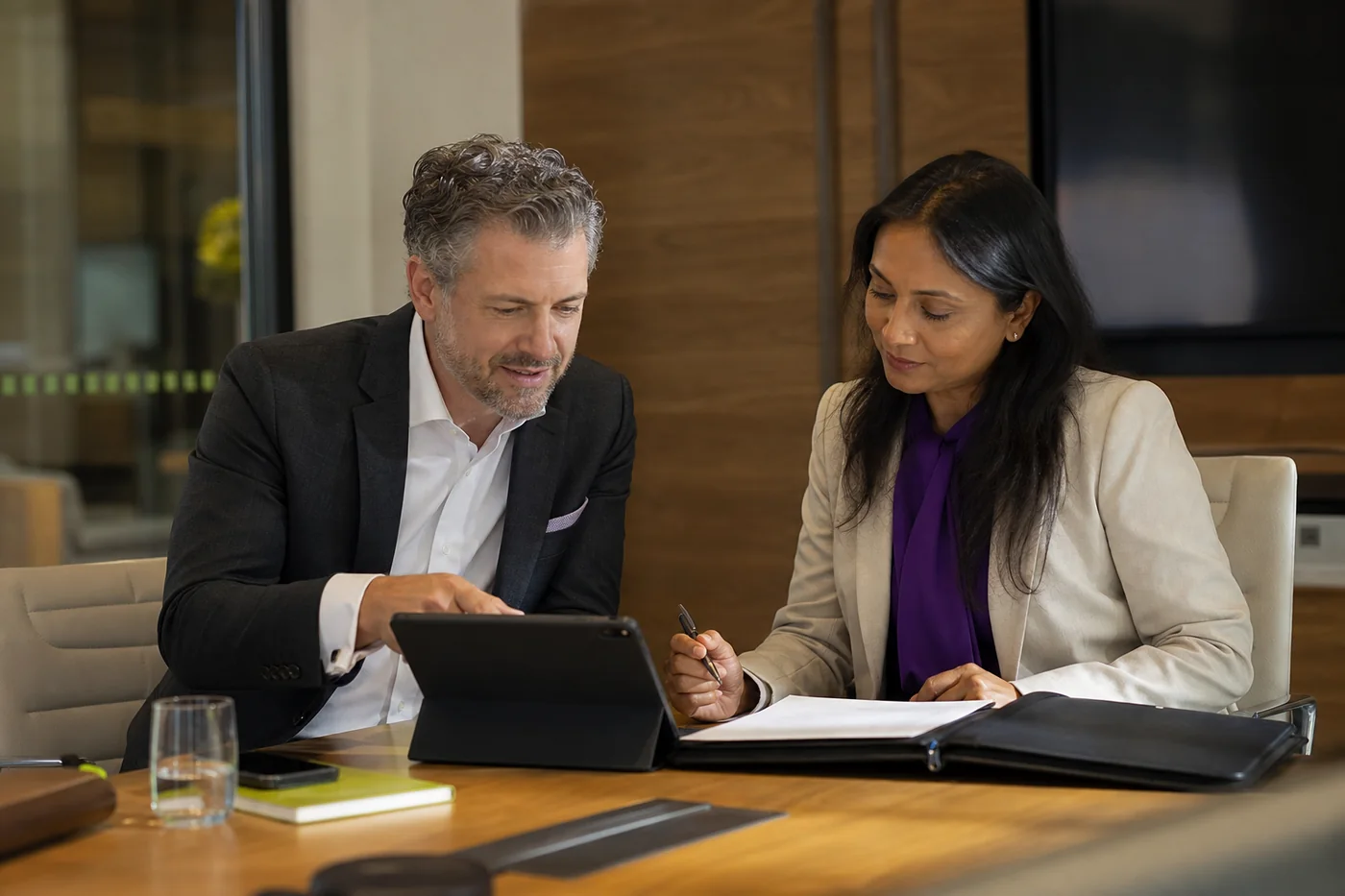 Account executive and business client reviewing and completing an agreement together